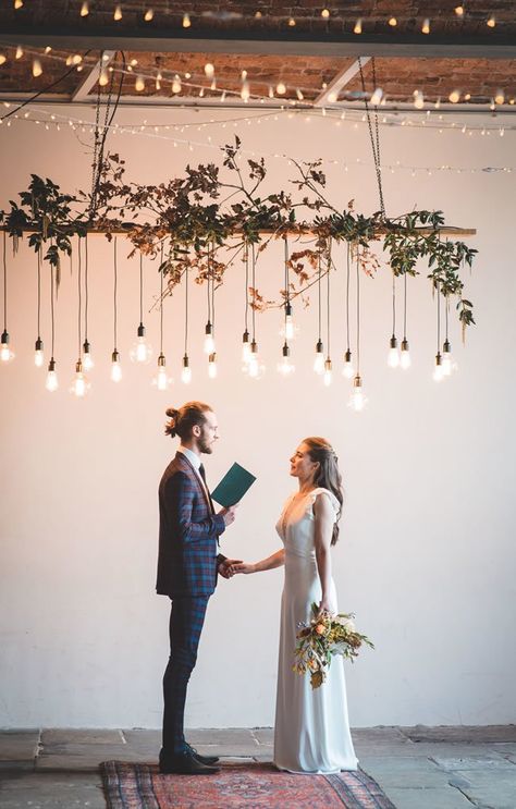 Edison lights hang overhead on this industrial wedding ceremony installation. Here are 6 Ideas for your Industrial Wedding Arch from Here Comes The Guide! #industrialchic #industrialwedding Industrial Wedding Arch, Industrial Wedding Ceremony, Ceremony Arch Decor, Bridal Things, Wedding Layout, Industrial Chic Wedding, Wedding Ceremony Arch, Ceremony Design, Party Tips