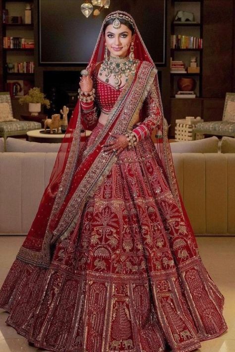 Experimenting with bridal lehengas is quite trending but let's agree that no matter what trend comes or goes, one that never changes is that of the classic red bridal lehenga. It is traditional, blazing and complements the Indian skin tone beautifully. That is why, one can never go wrong with this colour. And these days, there are such gorgeous ones which are a perfect mix of traditional and contemporary! Indian Bridal Wear Red, Bridal Wear Indian, Bride Lehenga, Dupatta Draping, Best Indian Wedding Dresses, Baju Kahwin, Latest Bridal Lehenga Designs, Red Bridal Dress, Bridal Lengha