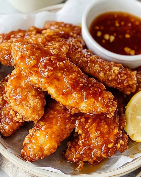 Hot Honey Chicken Tenders are the perfect balance of sweet and spicy, featuring crispy baked chicken tenders drizzled with a homemade hot honey sauce. The honey adds a delicious sweetness, ... Read more Really Easy Lunch Recipes, Honey Chicken Tenders And Mac And Cheese, Honey Chicken Meal Prep, Hot Honey Sauce Chicken Wings, Hot Honey Chicken Tenders Mac And Cheese, Honey Chicken Tenders Recipes, Hot Honey Tenders Recipe, Crispy Honey Chicken Tenders, Hit Honey Sauce