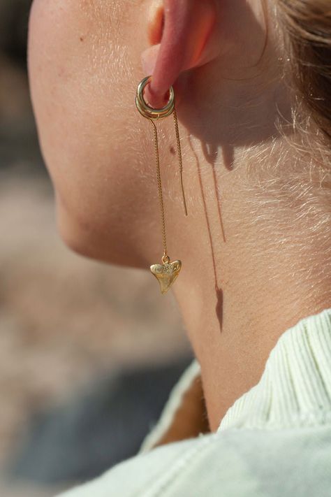 Mano - (mah NO) - shark.Gorgeous gold threader earrings. These gold dangle earrings feature stunning gold shark teeth charms. Minimal, edgy statement earrings reserved for only the truly chic.Handmade on Maui, Hawaii.✦ DETAILS ✦ ✧ 2.25" Length. ✧ 14kt gold filled. ✧ Gold Vermeil Shark Teeth (gold plated sterling silver).✧ This Ke Aloha Jewelry piece arrives in a tiny corked glass bottle beautifully packaged, ready for gift giving. Unique Gold Earrings For Beach, Handmade Ocean-inspired Gold Earrings, Gold Shark Tooth Earrings, Gold Shark Tooth Necklace, Gold Dangle Shell Earrings Ocean-inspired, Tooth Charm, Threader Earrings Gold, Shark Teeth, Threader Earrings