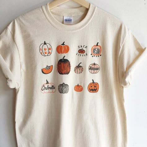 Hand Printed and Hand Drawn! This is a 100% cotton screen printed t shirt with a hand drawn illustration showing many varieties of pumpkins, like Lumina, Sugar,Cinderella, Connecticut Field and Jack be Little. Its perfect for fall! The shirt shown here is Natural and printed in orange and Screen Print Shirt, V Neck Shirts, Fall Things, Spooky Szn, Screen Printing Shirts, Halloween Cupcakes, Fall Feels, Fall Time, Pumpkin Shirt