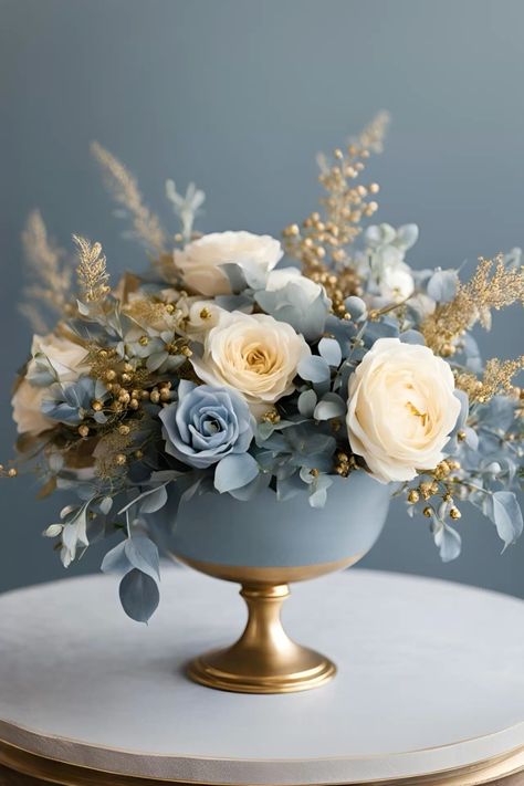 Elegant dusty blue, gold and cream floral wedding centre piece   #weddingcentrepiece #floralwedding #floralweddingtabledecor #floralweddingtablecentrepiece #dustybluewedding #dustyblueweddingideas #dustyblueandcreamwedding #dustyblueandcreamweddingflowers #dustyblueandcreamweddingtheme #dustyblueandcreamweddingdecor #dustyblueandgoldwedding #dustyblueandgoldweddingdecor Dusty Blue And Gold Wedding Decorations, Champagne And Dusty Blue Wedding, Blue Fall Wedding Theme, Dusty Blue Wedding Theme Centerpieces, Dusty Blue Centerpieces, Dusty Blue Centerpieces Wedding, Dusty Blue And Cream Wedding, Blush And Light Blue Wedding, Blue White Gold Wedding