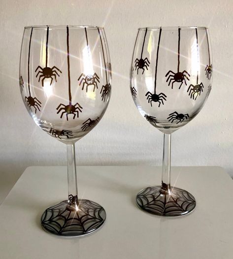 Happy Spooky Season!! This creepy crawly wine glass includes Hand Painted spiders! There are 8 spiders on webs and a few more below them on these MADE TO ORDER glasses. The spiders cover one half of the glass. Each spider has been detailed with 8 little legs and a set of two eyes (there should be 6.. but that's okay!). These spiders are descending from the top of the glass and on their way back to their spiderweb below! Depending on which glass style you choose, you will see a spiderweb on the bottom of your glass. These glasses are the perfect gift for any lover of spooky things, spiders, or Halloween fun!  I also offer several other Fall/Halloween designs. Please contact me if you would like to mix and match a SET of Glasses with others in my shop. I would be happy to create a "private l Halloween Diy Wine Glasses, Halloween Painted Shot Glasses, Halloween Cup Painting Ideas, Glass Halloween Decor, Halloween Glass Painting Ideas, Spooky Wine Glasses, Halloween Wine Glasses Diy Painted, Halloween Shot Glasses Diy, Halloween Painted Glasses