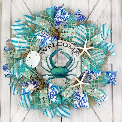 Welcome your family and friends with this adorable nautical wreath featuring a handmade 8” UV protected coastal wreath sign. Wreath is made with high quality weather resistant natural & ivory deco mesh with a touch of aqua blue fabric. It is decorated with finger starfish, a sand dollar and beachy ribbon that is spread throughout the wreath. | The Holiday Aisle® Welcome Crab 18" Deco Mesh Wreath Burlap / Deco Mesh in Blue / Green / White | 18 H x 18 W x 5.5 D in | Wayfair Beach Wreath Ideas, Coastal Wreath, Nautical Wreath, Seashell Wreath, Shell Wreath, Beach Wreath, Beach Diy, Blue Green Orange, Pillows Flowers