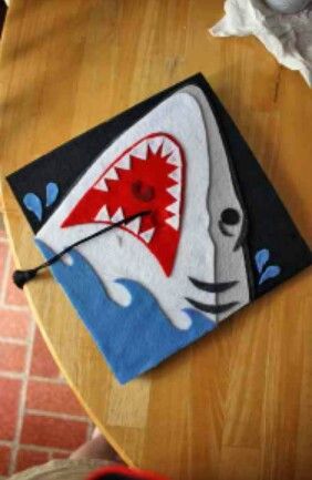 Felt shark for men interested in decorating their cap Shark Graduation Cap, Vpk Crafts, Grad Cap Design, Grad Hats, Shark Blanket, College Graduation Cap Decoration, Grad Hat, Grad Cap Designs, Diy Graduation Cap