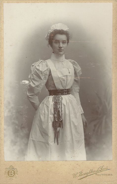 https://flic.kr/p/SxF6rR | Unidentified Nurse,Thetford Cabinet Card | the  Chatelaine attached to her belt looks to be so heavy that she needs a reinforced belt! Chatelaine Belt, Victorian Doctor, Victorian Maid, Nurse Aesthetic, Doctor Outfit, Vintage Nurse, Dress History, Uniform Dress, 19th Century Fashion