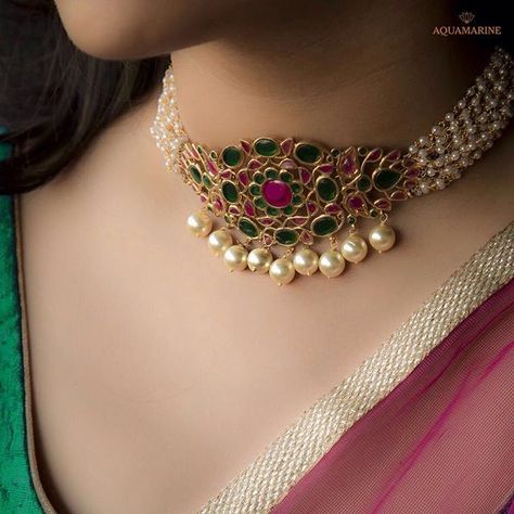 Magnicent and brilliant, this pearl choker necklace in bold green and pink with gold pearls at the bottom looks ethnic and royal. Available at Aquamarine. #aquamarine_jewellery #chokernecklace #goldpearls #green #pink #bold #designerjewellery #weddingjewellery #indianjewellery #mumbai #india #aquamarinejewellery Navratan Jewellery, Jewellery Styling, Indian Choker Necklace, Choker Necklace Designs, Gold Necklace Indian, Choker Designs, Pearl Necklace Designs, Gold Necklace Indian Bridal Jewelry, Stone Jewellery