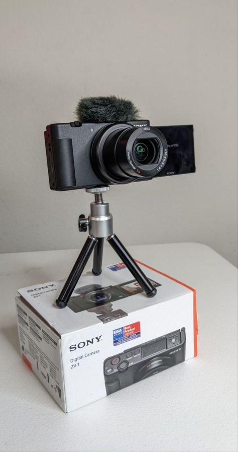 sony zv-1 on top of its box on a tripod. the wind guard is attached and the lens is open. Sony Zv1 Aesthetic, Sony Zv1 Camera, Gaming Camera, Electronics Branding, Sony Zv1, Sony Video Camera, Camera For Photography, Best Vlogging Camera, Start Youtube Channel