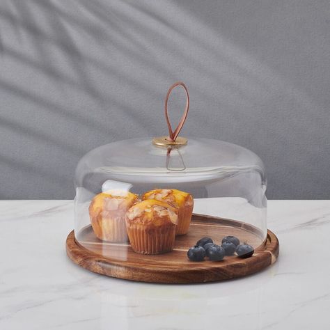 Combining clear glass with an acacia wood base, this elegant Glenwood Cake Dome brings contemporary style to any gathering. Ideal for elevating the presentation of cakes, pies, cookies, appetizers, and more, this eye-catching plate is perfect for protecting food from the air when serving guests. A faux leather loop on top makes removing the dome easy. 2-piece set includes glass dome and wood base. • Measures 5 inches high with a 9-3/4 inch diameter. • Crafted of Acacia Wood and Lead-Free Glass. Cake Plate With Dome, Glass Cake Dome, Cake Dome, Cake Plate, Glass Dome, Cake Plates, Glass Domes, Acacia Wood, Serveware