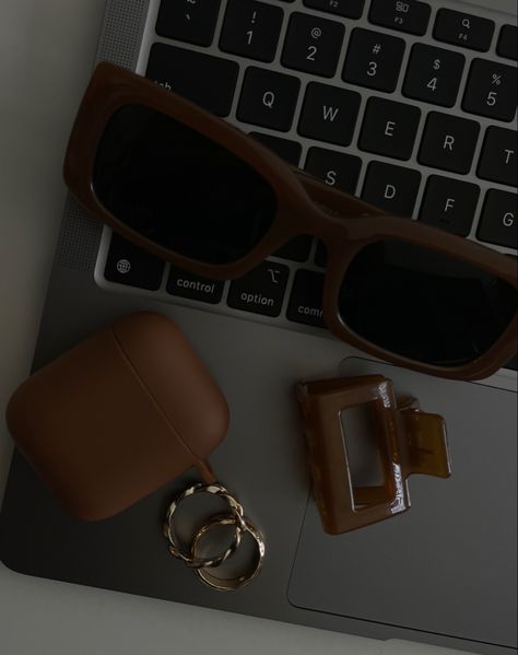 Brown sunglasses, small brown claw clip, brown airpods and gold rings on a macbook Brown Business Aesthetic, Black White And Brown Aesthetic, Brown Aesthetic Black Women, Brown Woman Aesthetic, Warm Aesthetic Brown, Brown Rich Aesthetic, Deep Brown Aesthetic, Brown Moodboard Aesthetic, Brown Asthetics Photos