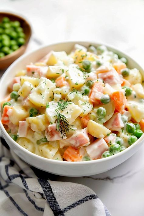 If you've never had Olivier salad before, you're in for a treat! This Russian delicacy is packed with carrots, potatoes, peas, ham, and pickles in a delectable dressing. Potato Salad With Peas And Carrots, Russian Potato Salad, Olivier Salad, Carrot Salad Recipes, Thanksgiving Brunch, Potato Salad With Egg, Carrots Potatoes, Pea Salad, How To Cook Ham