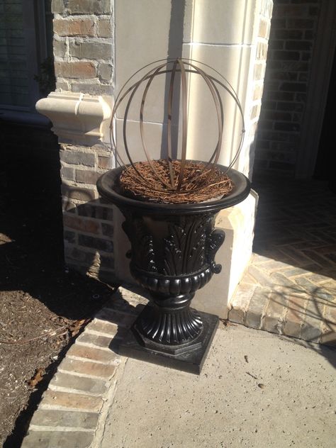 Finally a way to fill my urns in the winter. A metal orb and grapevine wreath. Weighted down with a brick. Metal Orbs In Planters, Rusty Decor, Winter Porch Pots, Porch Urns, Backyard Christmas, Front Porch Landscape, Outdoor Planter Ideas, Porch Pots, Winter Planters