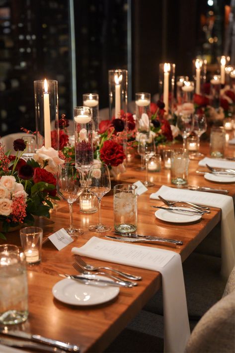 Red rose, burgundy ranunculus, blush rose, blush spray rose, red genistra - white taper candles, stemmed hurricanes with floating candles - farm table centerpiece Red Wedding Table Decor, Red Floral Centerpieces, Blush Spray Rose, Wedding Farm Table, Blush Winter Wedding, Farm Table Centerpiece, Wedding Flower Table, Burgundy Ranunculus, White Taper Candles