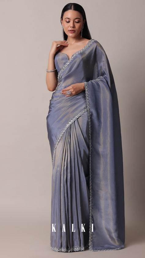 "Effortlessly combine femininity and fashion with this elegant and classy saree. Set in a grey hue, it is crafted from high quality glass tissue fabric. Detailed with intricate mirror work on the border, it flaunts a scallop cutwork border and stone studded embellishments. Paired with an unstitched blouse piece, this drape is a must-have addition to any wardrobe.

" Scallop Saree Border, Western Blouse Designs Latest, Classy Sarees Elegant, Elegant Saree Classy, Tissue Organza Saree Blouse Designs, Grey Blouse Designs, Grey Saree Blouse Combination, Tissue Saree Blouse Designs Latest, Elegant Saree For Farewell