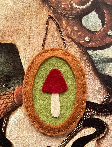 I made this miniature wall hanging with beautiful merino wool felt in earthy tones, creating a faux frame with a sweet little mushroom and a chain. Only one is available. It would make a perfect addition to a gallery wall with a small empty space to ill measures approximately 4" x 2"  (length is hanging with the chain) Felt Home Decor Diy, Embroidery Felt Ideas, Felt Hanging Decorations, Felt Decorations Diy, Felt Embroidery Projects Ideas, Waldorf Felt Crafts, Felt Sheet Crafts, Felt Diy Projects, Diy Felt Projects