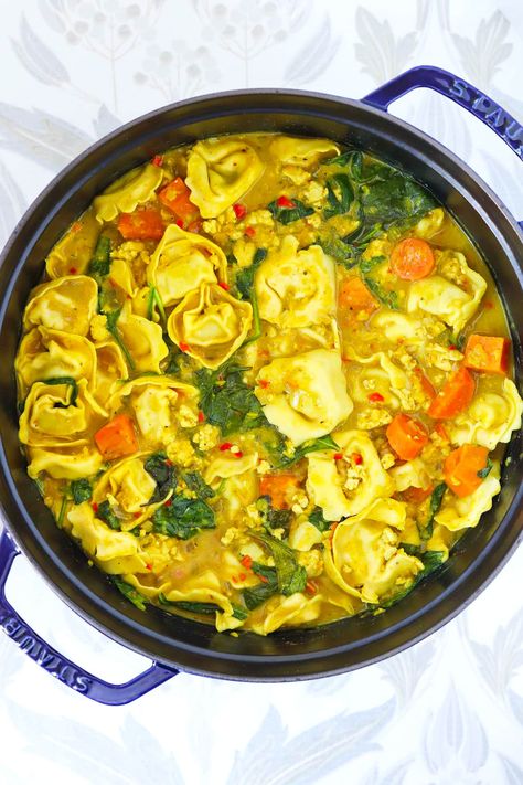 Thai Yellow Curry Tortellini Soup is easy to make in one pot and full of aromatic Thai yellow curry flavors and warming spices! It’s made with ground chicken, red split lentils, feel-good veggies and savory parcels of tortellini in a thick and creamy coconut milk broth. Wholesome, cozy and filling, it's perfect for a cold winter day!  #thaiyellowcurry #chickensoup #comfortfood #highproteinmeals #dinner #thaifood #asianfood #onepotmeals #mealprep #highprotein #healthy | That Spicy Chick Thai Yellow Curry, Red Split Lentils, Curried Lentil Soup, Chicken Tortellini Soup, Spinach Tortellini, Healthy Party Food, Yellow Curry, Easy Main Dishes, Curry Recipes Indian