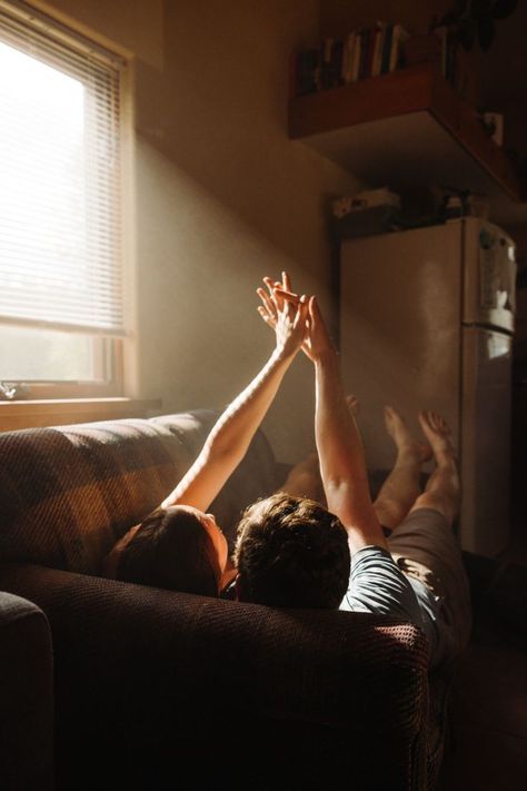 Man and woman holding hands in the air while laying on their conch for their intimate engagement session Indoor Engagement Photos, Creative Couples Photography, Lifestyle Photography Couples, Cozy Romantic, Home Photo Shoots, Romantic Photoshoot, Engagement Pictures Poses, Hilarious Pictures, Indoor Photography