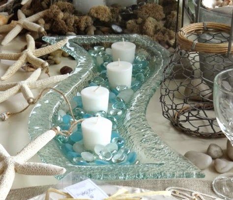 Top Coastal Candle Centerpieces for a Warm & Festive Table..wavy bubble glass..looks like a steam of water with pebbles. Coastal Centerpiece, Coastal Candle, Seaside Decor, Beach Theme Decor, Beachy Decor, Coastal Christmas, Centerpiece Ideas, Festive Tables, Coastal Design