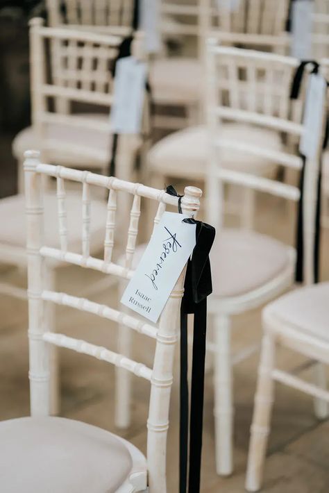 Monochrome Black & White Luxe Wedding at Wollaton Hall with chairs decorated with black ribbon and reserved seat tags Wedding Ceremony Seating Decor, Wedding Chairs With Ribbon, Reserved Ribbon Wedding, Reserving Seats At Wedding, Reserved Ceremony Seating, Black White Winter Wedding, Wedding Chair Sashes Ideas, Wedding Ceremony Reserved Seating Signs, Black Bow Wedding Decor