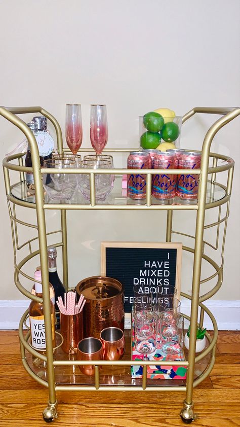 Anthropologie Apartment Decor, Bev Cart Ideas, Bev Cart Apartment, Pink Bar Cart Aesthetic, Good Bar Cart, Preppy Coffee Bar, Bar Cart Must Haves, Decorated Bar Cart, Trendy Bar Cart