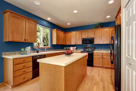 If you have honey oak in your home and want to change up its look, you can still use a fresh coat of paint to liven up your walls and tame those cabinets. Oak Kitchen Cabinets Wall Color, Honey Oak Trim, Blue Kitchen Walls, Best Wall Colors, Honey Oak Cabinets, Paint For Kitchen Walls, Oak Cupboard, Hale Navy, Oak Trim