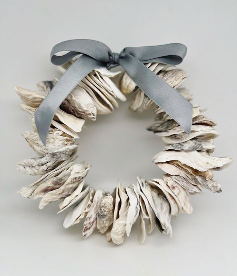 Sweet, small oyster wreath made with oyster shells and finished with your choice of beautiful ribbon. You may choose from sea gray silk charmeuse, Atlantic Storm Velvet, cognac velvet, Oyster Shell Frayed-edge Cotton or cream-beige and mauve (pink) silk charmeuse.  This oyster shell wreath measures  7.5-8" in diameter and is the perfect size to use as an accent piece for a shelf, picture wall, mantle, etc. Oyster shells have been left natural, finished by the sea, sand and sun and have a beautiful, weathered patina. You will love this little wreath! Perfect to give as a gift, or to add a little coastal flair to your own home. The wreath shown is representative of the wreath you will receive. All oysters are unique and have been carefully chosen by me. Each wreath is one of a kind and beaut Oyster Wreath, Oyster Shell Wreath, Oyster Decor, Oyster Shells Diy, Oyster Shells Decor, Coastal Wreath, Oyster Shell Crafts, Seashell Wreath, Shell Wreath