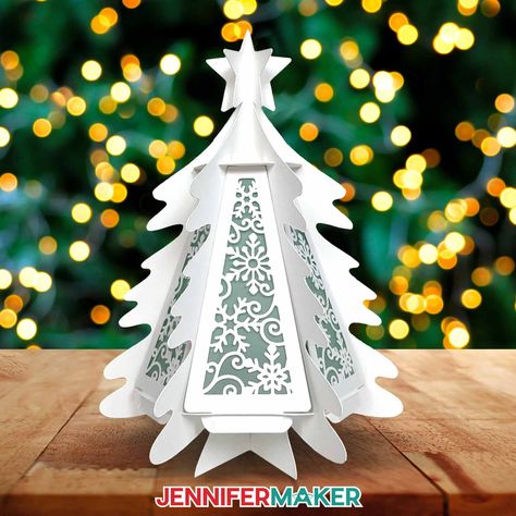 Learn how to make a 3D paper tree lantern with JenniferMaker's tutorial! A cardstock tree sit illuminated against a background lit with Christmas lights. Paper Lantern Template Free Printable, Cricut Luminaries, Lantern Template Free Printable, Christmas Paper Lanterns, 3d Paper Tree, Christmas Toyland, Shadowbox Diy, Paper Craft Christmas, Royal Icing Templates