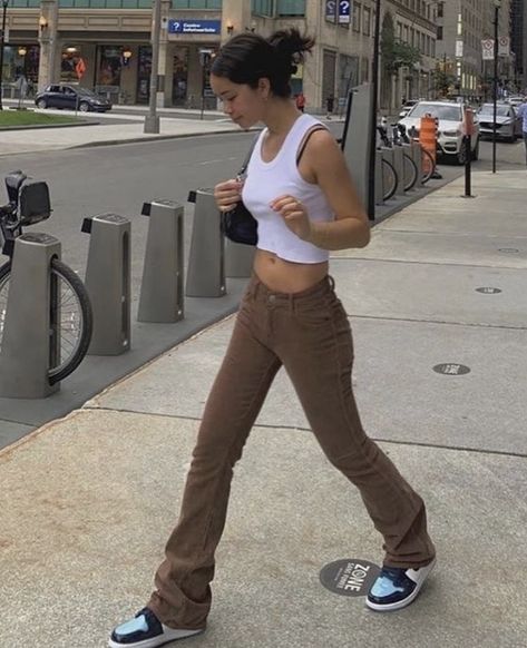 white cropped tank top paired with low waisted brown jeans, a black shoulder bag or baguette purse, and air jordan 1 retros unc patent leather, pinned up hairstyle #hair #hairstyles #purse #brown #outfits #outfitideas #fashion #sneakers #jeans #cropped Mode Dope, Looks Pinterest, Brown Jeans, Brown Outfit, School Looks, Looks Street Style, Streetwear Fashion Women, Indie Outfits, Mode Inspo