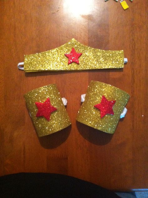 DIY Wonder Woman tiara and bracelets. Tiara: found a template on Pinterest for the shape of the crown. Then traced it onto peel &stick glitter foam sheet, cut it out. Hot glued a piece of felt to the back of the peel and stick (for something soft against the skin) Finally, I took a piece of elastic and hot glued it in between the glitter foam and felt. Bracelets, two toilet paper rolls cut for openings then cut and glued glitter foam sheets to them. Stars are peel and stick glitter foam als... Wonder Woman Tiara, Wonder Woman Costume Diy, Diy Superhero Costume, Diy Fantasia, Wonder Woman Birthday Party, Women Party Ideas, Wonder Woman Party, Wonder Woman Birthday, Diy Costumes Kids