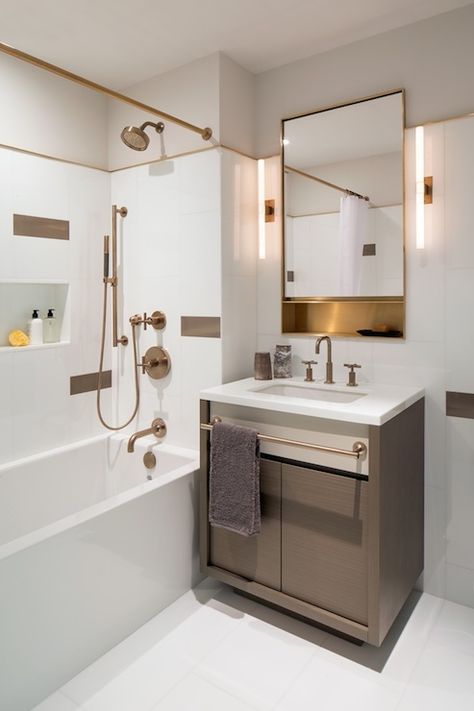 Gorgeous bathroom features taupe veneer vanity with built-in towel bar topped with white quartz framing single bowl sink paired with brass gooseneck faucet under gold vanity mirror flanked by slim wand light sconces. Gold Vanity Mirror, White Bathroom Cabinets, Bathroom Features, Towel Holder Bathroom, Bathroom Wall Cabinets, Gorgeous Bathroom, Modern Vanity, Makeover Ideas, Bar Ideas