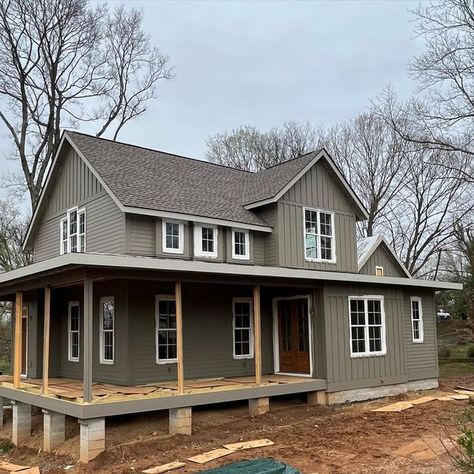 Debbie Woodard on Instagram: "The painting of FOXRUN 🦊 FARMHOUSE is almost finished!!! We don’t want the house to look “Victorian”. Rather our vision is for the house to have a more monochromatic New England feel. Thus we chose a darker gray color with just a shade lighter trim for the windows & doors. Next the standing seam slate color metal roof will be installed. Flooring is now being installed on the wrap around porch. Not sure weather to stain or paint the porch floor." Dark Gray Metal Roof, Light Gray Roof House Colors, Gray Roof House Colors, Gray Metal Roof Houses Color Combos, Metal Roof Houses Color Combos, Dark Exterior House, Painted Brick House Exterior, Dark Grey Houses, Outside House Paint