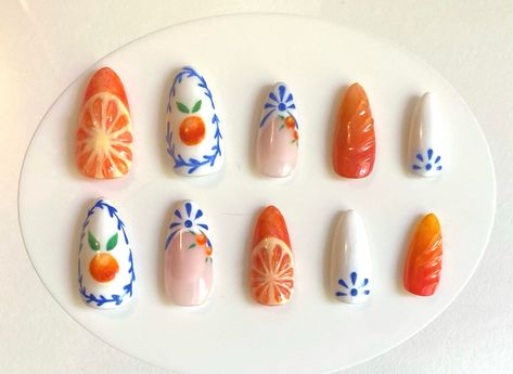 Hand painted citrus nails perfect for summer! Original design with 3d oranges and blue and white pattern inspired by trendy summer design by various other nail artists.  Medium length, almond nail,  *please send sizing information otherwise press ons may not fit! (check sizing photo and pick size 0-9 for each nail) Includes: Press ons, rubber cuticle pusher, nail file, nail buffer, nail glue, glue tabs, alcohol pads, organza bag Fair Themed Nails, 3d Orange Nails, Hand Paint Nail Art, Hand Painted Press On Nails, Farmers Market Nails, Clementine Nails, Custom Press Ons, Art Deco Nails Designs, Spring Summer Nails