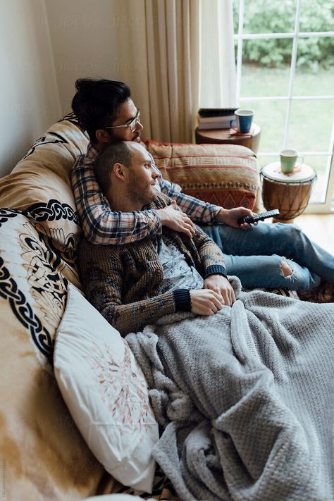 Young Gay Couple Realxing On The Couch Of The Living Room Watchi Cuddling On Sofa Pose, Couch Cuddle Reference, Couple Sofa Cuddling, Couples Sitting Together Couch, Couple Sitting On Couch, Couple On Couch, Couple Snuggling Couch, Best Living Room Ideas, Room Ideas For Girls