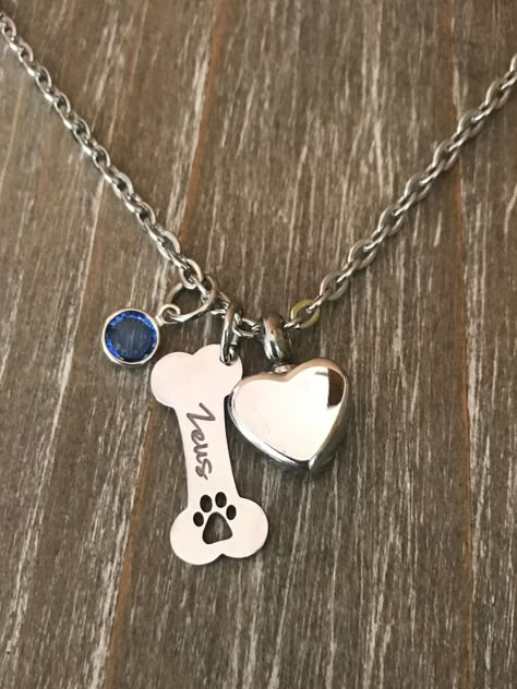 Listing is for custom Completed Pet Cremation urn Necklace, Necklace includes pendant with your choice of pet Name on bone ( up to 10 characters ) with birthstone and Heart cremation Urn to hold a small amount of ashes. Pendants come on a 18 inch Stainless Steel chain. 24 inch is available on request Bone has cut out paw print at end :) IF PURCHASED ALL URNS ( WHETHER ADDING ASHES OR NOT ) MUST BE GLUED SECURELY SHUT BEFORE WEARING OR ADDING TO KEY CHAIN. Bone with name is approx. 1 inch Stainle Dog Memorial Jewelry, Pet Ashes Jewelry, Dog Lover Jewelry, Pet Cremation Urns, Pet Memorial Necklace, Pet Cremation, Urn For Ashes, Pet Ashes, Urn Necklace