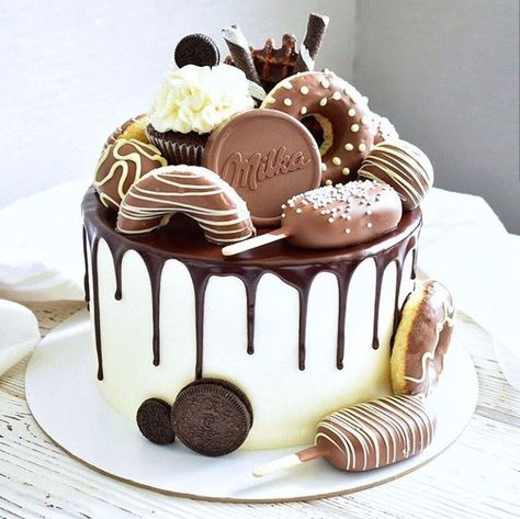 This overloaded drip cake would be perfect for any chocoholic, complete with chocolate doughnuts, milka chocolate, oreo cookies, cupcakes and cakesicles! Tårta Design, Candy Birthday Cakes, Chocolate Cake Designs, Chocolate Drip Cake, Chocolate Cake Decoration, Candy Cakes, Birthday Cake Chocolate, Beautiful Birthday Cakes, Cake Decorating Designs