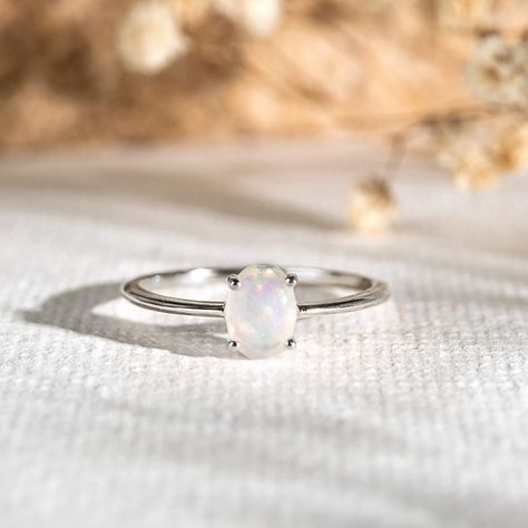 A simple opal ring with a dainty silver band…but it’s anything but ordinary! With its iridescent rainbow hues and four-prong setting, this stunning ring will add a magical glow to your stacks. Opal stone measures at 7x5 mm. Simple Opal Ring, Opal Ring Simple, Opal Wedding Ring Set, Opal Ring Silver, Moonstone Engagement Ring Rose Gold, Opal Band Ring, Promise Rings Simple, Silver Opal Ring, Silver Rings Simple