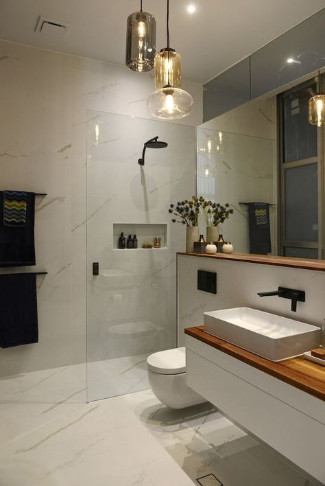 White marble wall tiles in bathroom / wood shelf and wood bench in bathroom / glass pendant lights in bathroom / Laufen basin #interiordesing #bathroominteriors #moderninteriordesign Design Interior Baie, Bathroom Wood Shelves, Modern Bathroom Lighting, Decor Baie, Bathroom Pendant Lighting, Glass Bathroom, Contemporary Bathrooms, Wood Bathroom, Bathroom Layout