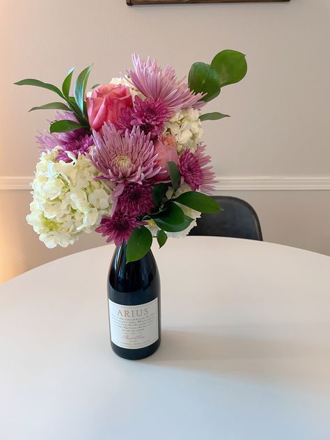 Centerpiece Wine Bottle, Flower Arrangement On Top Of Wine Bottle, Wine With Flowers On Top, Flower Bouquet On Wine Bottle, Flower Bouquet With Wine Bottle, Wine Bottle Floral Bouquet, Champagne Bottle Flowers Bouquet, Floral Wine Bottle, Wine Floral Arrangements