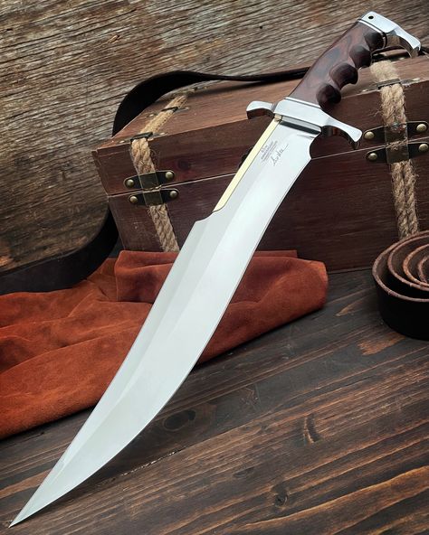 We are proud to offer the Gil Hibben 65th Anniversary Spartan Bowie and Display Stand to celebrate Gil Hibben's incredible legacy! The knife features an imposing 15 1/8" 5Cr15 stainless steel upswept blade with a mirror polished finish and a polished brass spine accent. The dark pakkawood handle features comfortable finger grooves and a hefty chrome-plated handguard and pommel. The 20 5/8" overall knife can be displayed on the included wooden stand, which features a 65th anniversary coin. Best Bowie Knife, 65th Anniversary, D2 Steel, Cool Knives, Bowie Knife, Camp Knife, Wooden Stand, Hunting Knife, Axes