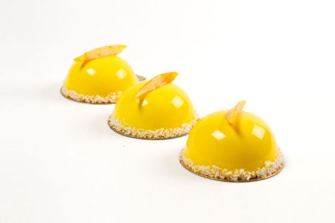 These mango dômes are a bright, tropical work of art to light up the room. Already pre-portioned in individual servings, you can bring them to a brunch or dinner party to steal the show. Further, the glaze and syrup-soaked mango garnish keep the cake fresh so you can prepare this entremet up to two days before serving. Entremet Cake, Mirror Glaze Recipe, Entremet Recipe, Chocolate Mirror Glaze, Mango Mousse Cake, Mirror Glaze Cake Recipes, French Baking, Mango Mousse, Mirror Glaze Cake