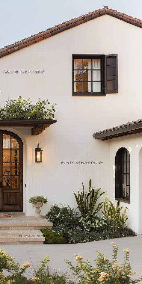 The modern farmhouse facade features clean lines and natural materials, creating a welcoming yet stylish entrance. Mediterranean House Exterior Modern, Modern Farmhouse Facade, Medditeranean Style Home, Farmhouse Facade, Modern Spanish Farmhouse, Spanish House Exterior, Spanish Style Exterior, Modern Farmhouse Exterior Design, Colonial Modern