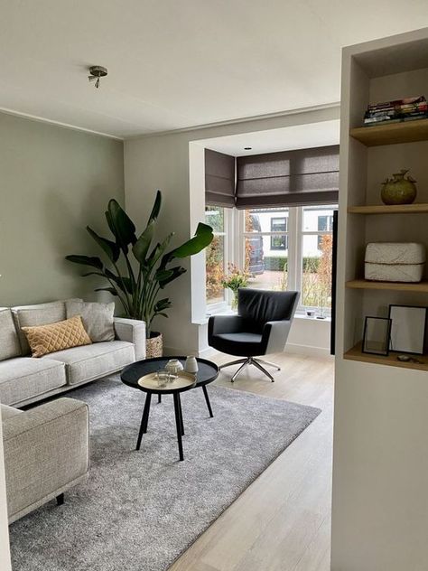 Picture of a modern living room with an olive green accent wall, a grey sectional, a black coffee table, and a chair and some storage units Olive Green Accent Wall, Olive Living Rooms, Sage Living Room, Green Accent Wall, Sage Green Living Room, Green Living Room Decor, Green Living Room, Black Coffee Table, Grey Couch Living Room