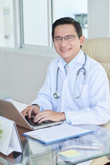 Free photo successful doctor working at ... | Free Photo #Freepik #freephoto #doctor-computer #doctor-laptop #asian-doctor #hospital-doctors Successful Doctor, New Photo Download, Doctor Office, Medical Professionals, Free Photo, Free Photos, Medical, Stock Photos