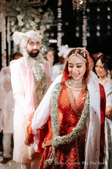 Indian wedding, phera ceremony, bride in red lehenga, traditional bridal jewellery, wedding garlands, baby's breath varmala, Indian bridal wear, elegant bridal attire, traditional Indian wedding dress, wedding photography, wedding portraits, bridal look Indian, wedding themes, wedding celebrations, beautiful bride, stylish groom, phera shot, wedding rituals, bridal mang tikka, nose ring, jewellery for indian bride, traditional look for bride Varmala Indian Weddings, Bride In Red Lehenga, Indian Bride Traditional, Traditional Indian Wedding Dress, Bridal Look Indian, Lehenga Traditional, Indian Wedding Dress Traditional, Traditional Bridal Jewelry, Turkey Wedding