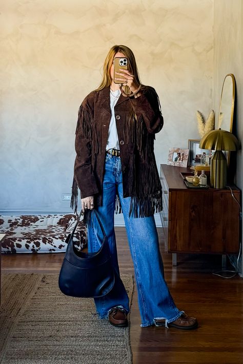 In love with these soft wide leg distressed jeans! Paired them with a classic white t-shirt, brown leather belt, boat shoes, my favorite vintage brown suede 1970s fringe jacket and a vintage coach bag.  #falloutfitideas #fringejacket #suedejacket #falltrends #classicstyle #quietluxury #widelegjeans Brown Suede Belt Outfit, Western Fringe Jacket Outfit, Fringe Suede Jacket Outfit, Western Cold Weather Outfit, Western Jacket Outfit, Brown Fringe Jacket Outfit, Cold Weather Western Outfits, Fringe Leather Jacket Outfit, Cold Weather Country Concert Outfit