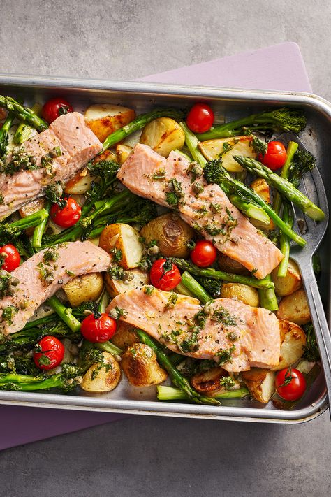 Four salmon fillets in a roasting tray on top of new potatoes, tomatoes and asparagus. Georgina Hayden, Salmon Tray Bake, Traybake Dinner, Oven Baked Salmon Recipes, Tartiflette Recipe, Low Carb Potatoes, Lemon Pepper Salmon, Nadiya Hussain, Oven Baked Salmon