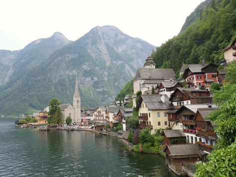 Lovely little town on a cliff next to a lake. It is called #Hallstadt . #city #town #greatview #mountain #buildings #alps #lake #landscape #outdoors #foggy #oldbuildings Mountain Aesthetic, Mountain City, Location Inspiration, City Pictures, Lake Pictures, Mountain Village, Lake Landscape, Mountain Town, City Landscape