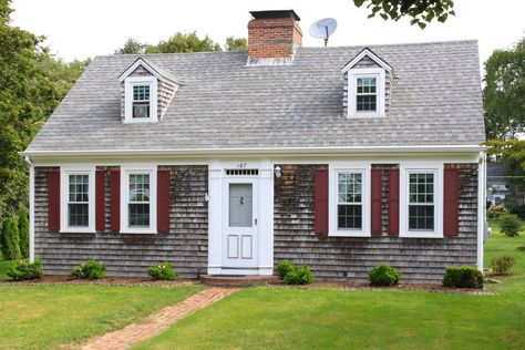 New England House with grey shingles, two small dormers without shutters, red shutters on four first-floor windows, dish antenna on roof House With Front Porch, Cape Cod Architecture, Cape Cod Exterior, Cape Cod House Plans, Farm Style House, Modern Courtyard, Cape Cod Style House, Colonial House Plans, Farmhouse Floor Plans