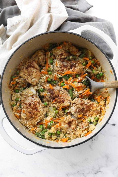 Juicy, perfectly seasoned chicken thighs combine with rice and veggies in this easy one pan dutch oven chicken and rice recipe. Only 15-minutes of active cooking time and 6 main ingredients for an easy and healthy weeknight dinner. It's seriously the best one pot chicken and rice recipe! It's great for leftovers, meal prep and freezer friendly. Chicken Stew Dutch Oven, Dutch Oven Recipes Healthy Clean Eating, Chicken And Rice Dutch Oven Recipes, One Pot Chicken Thigh Recipes, Chicken Thighs Dutch Oven, Dutch Oven Rice, Dutch Oven Chicken And Rice, Healthy Dutch Oven Recipes, Chicken Rice And Veggies