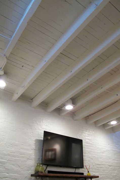 Exposed ceiling in a shallow basement - paint the rafters instead of covering them up to make the space look larger Stylish Basement, Exposed Basement Ceiling, Basement Paint, Basement Ceiling Options, Low Ceiling Basement, Exposed Ceiling, Basement Painting, Basement Lighting, Basement Inspiration